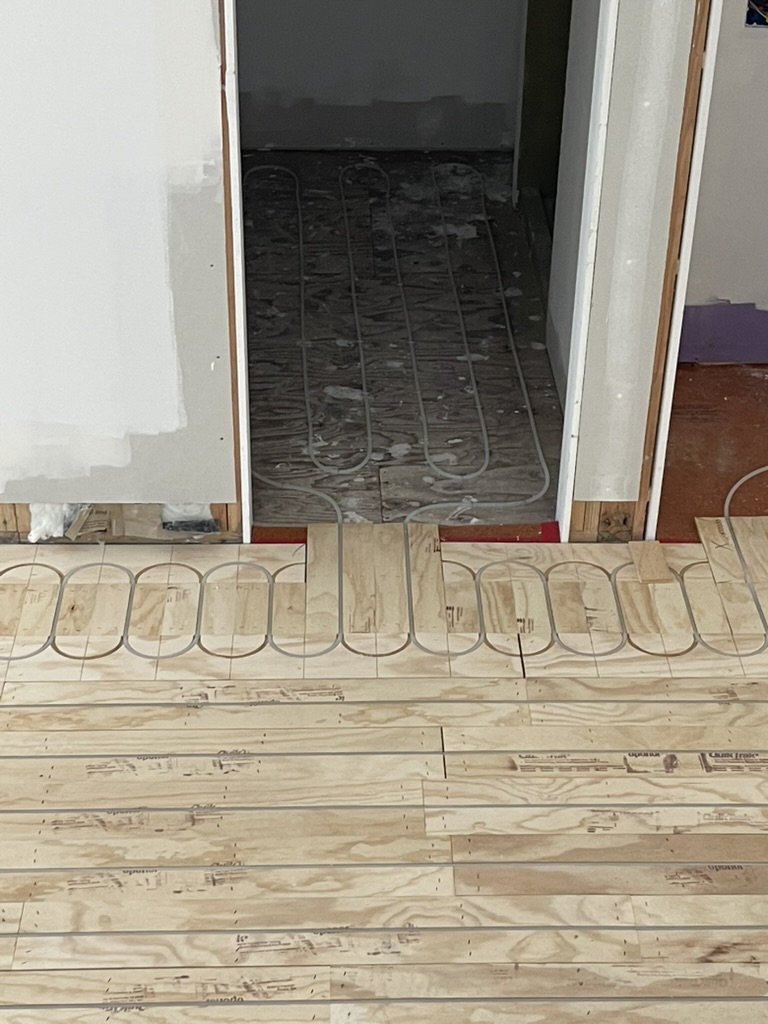 Radiant heating tubing transitioning between rooms