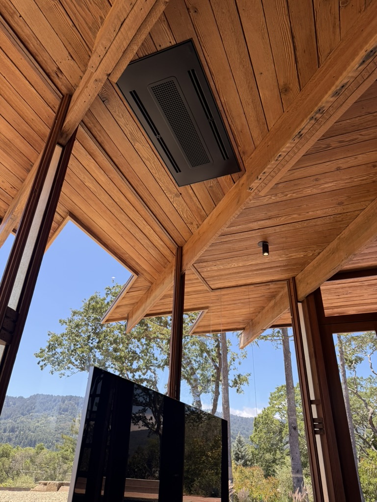 Ceiling-mounted fan coil unit in a wood-clad room