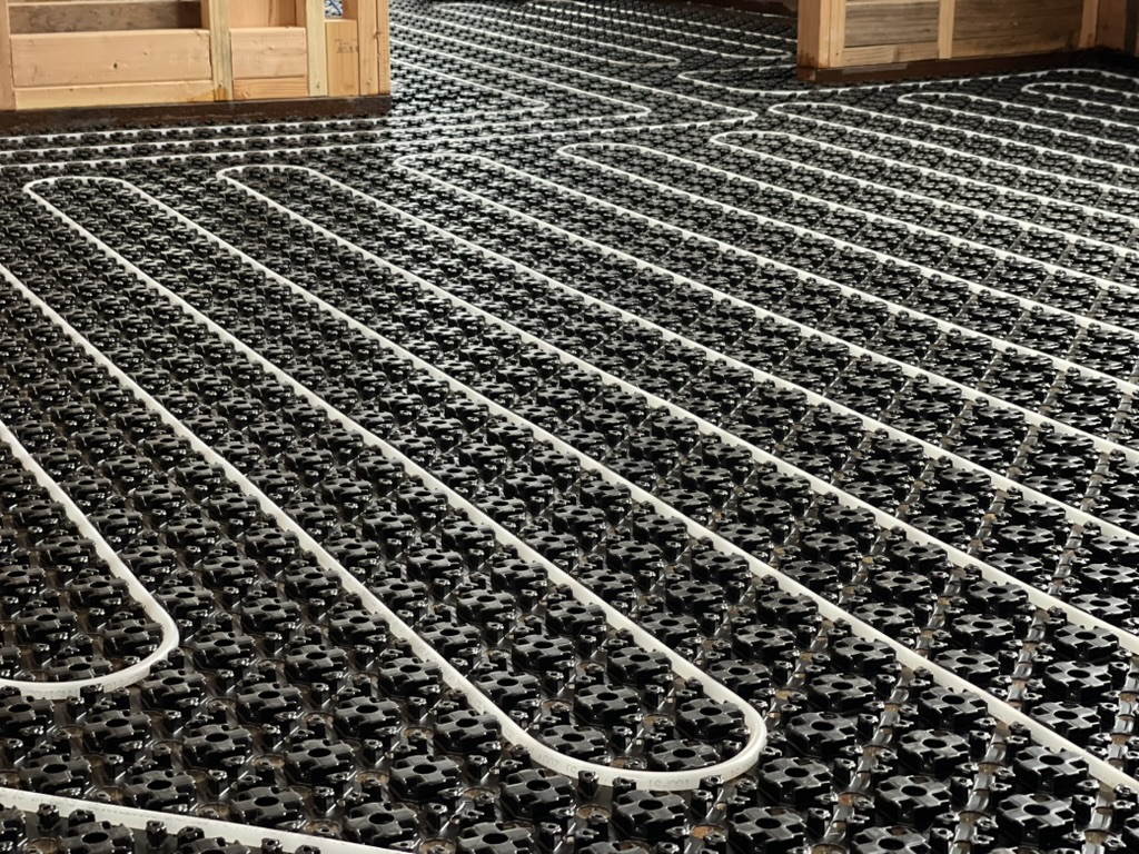 Close-up of radiant PEX loops across studded mat