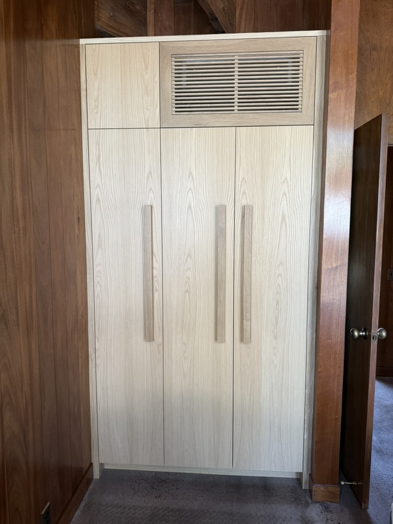 Custom cabinetry integrating a fan coil intake grille