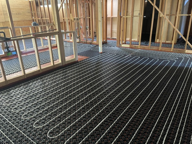 Radiant floor PEX tubing on studded mat in new construction